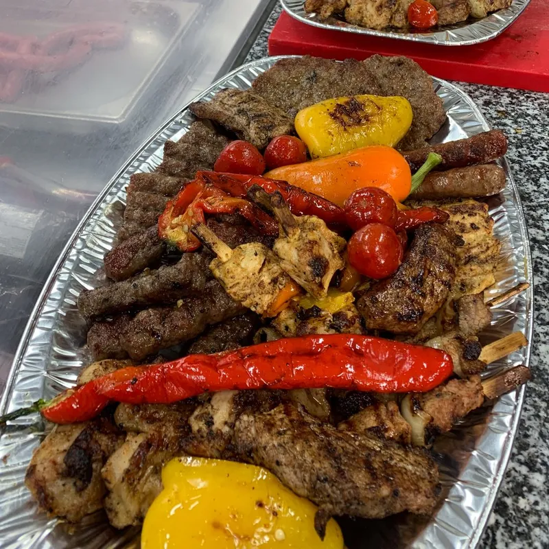 En plåt med cevapcici, pljeskavica, kött, kyckling, chili, tomater.
