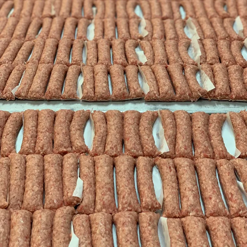 Väst Grillens råa cevapcici uppradat på bakplåtspapper.